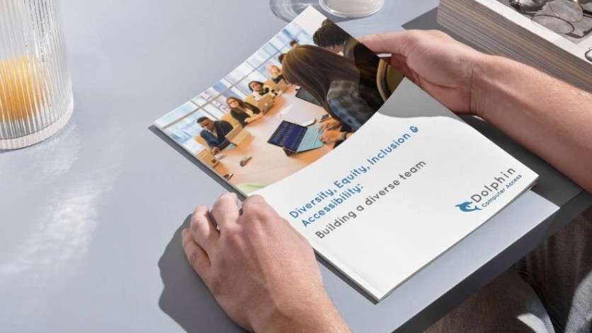 Hands holding a printed copy of the DEIA Guide